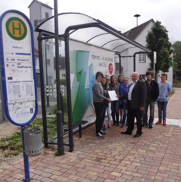 Eine Hahner Schülergruppe rund um die Initiatorin Lina Kramer (1.v.l.) übergab jetzt vor der Bushaltestelle Rathaus ihre gesammelten Unterschriften an Bürgermeisterkandidat Hansgeorg Schiemer (re.)